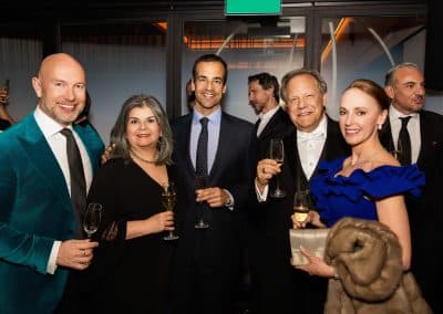Group of elegantly dressed people smiling.